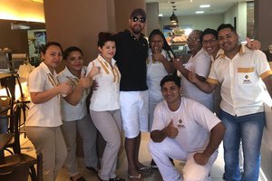 Ele aparece pousando em foto junto com os funcionários, que nas redes sociais passaram a exaltar a sua coragem e determinação em enfrentar o cantor. (Foto: Reprodução)